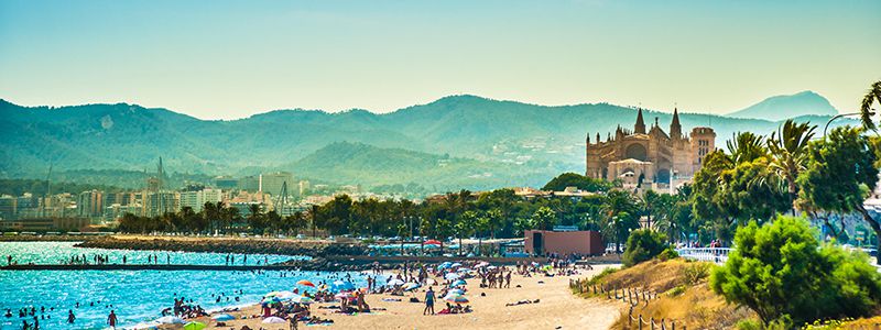 Sandstrand på Palma med bergen i bakgrunden.